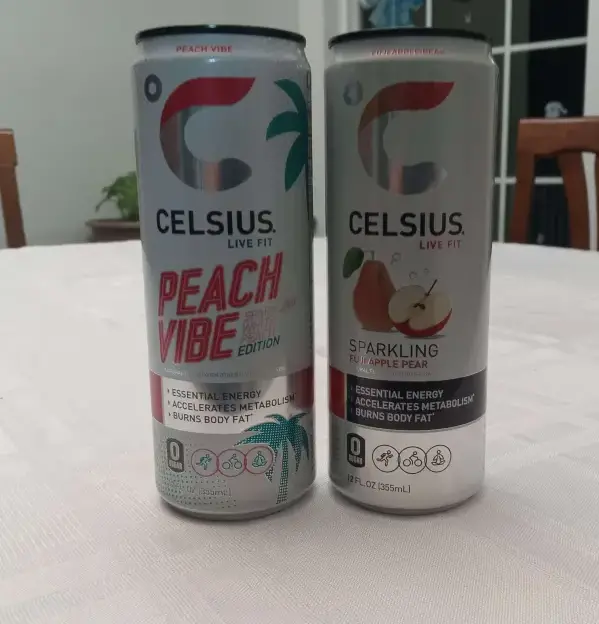 Peach vibe celsius and Sparkling pineapple pear celsius drink on table luxwisp